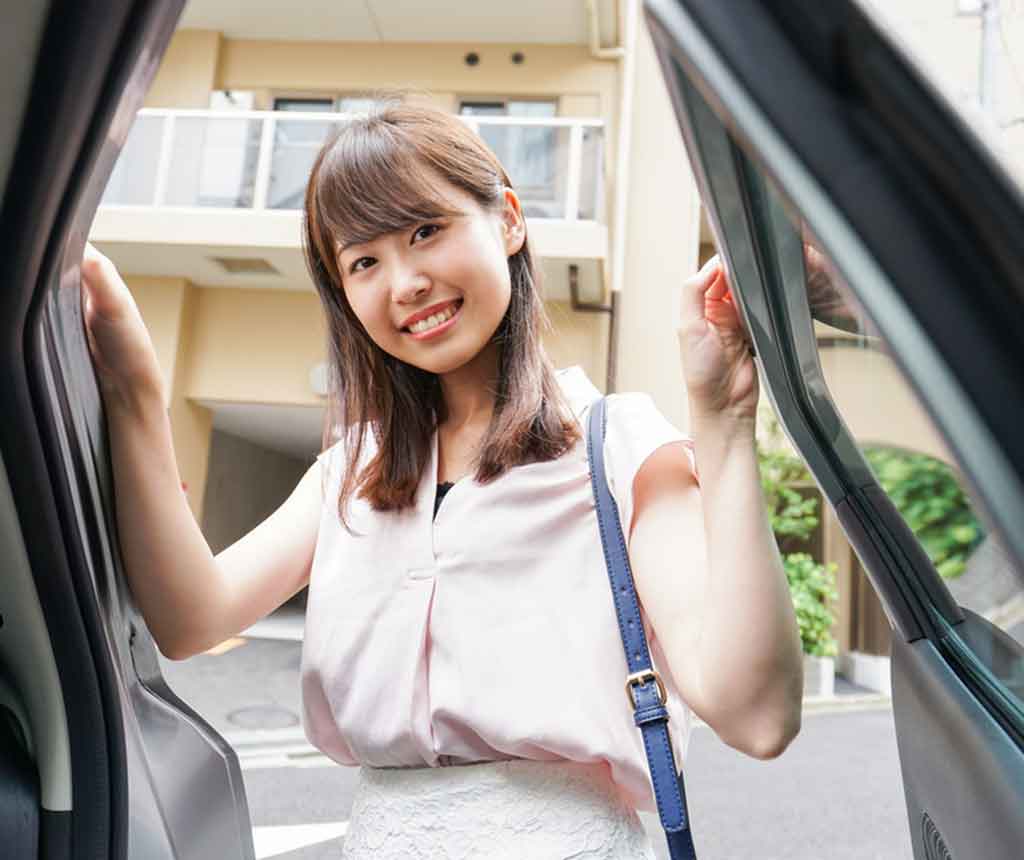 笑顔で車に乗り込む女性